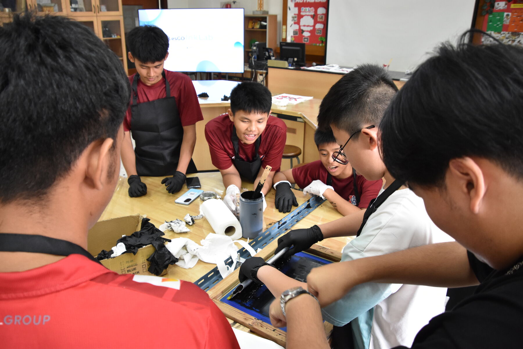 Students gather round a screen as one of them prints